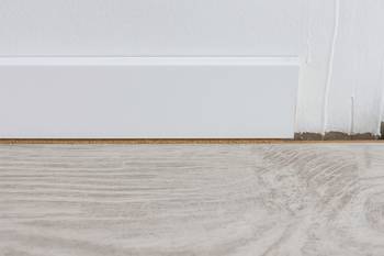 Lorsque vous posez un parquet, les finitions sont essentielles pour un rendu parfait. Découvrez comment combler l'espace entre une plinthe et du parquet.